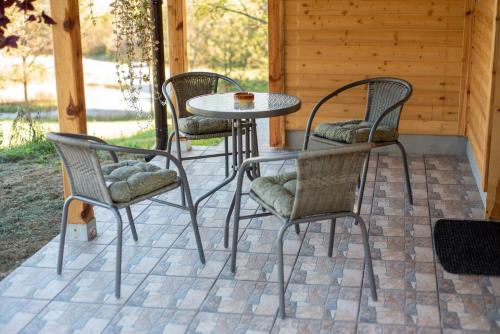 four chairs and a table on a patio at Brvnara Brkovic 2 in Čajetina