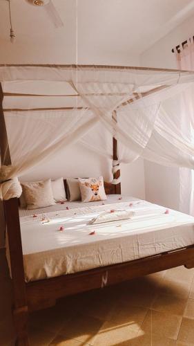 a bedroom with a bed with a canopy at Marion's incredible 2 bedroom apartment in Watamu