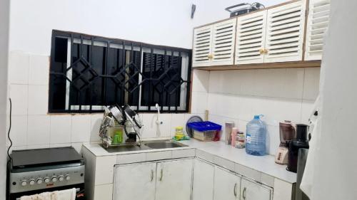 a small kitchen with a sink and a stove at Marion's incredible 2 bedroom apartment in Watamu