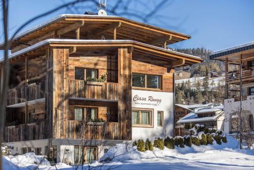 a log cabin in the snow with a sign on it at Ciasa Rungg Monte Sella Suite in San Vigilio Di Marebbe