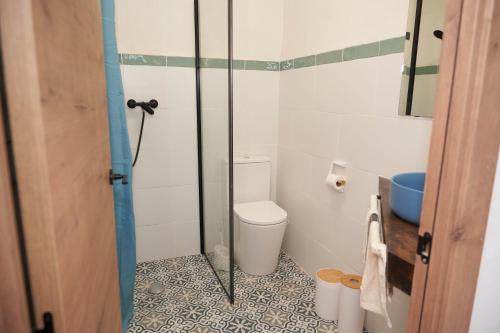 a bathroom with a toilet and a glass shower at El mas allà in Chulilla