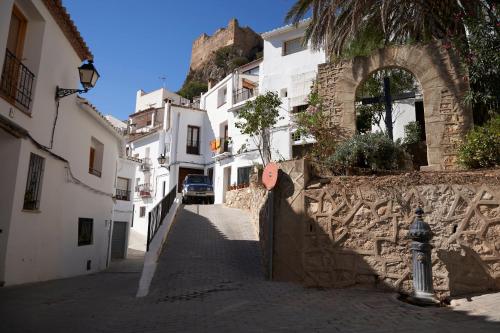 a narrow street with white buildings and a fire hydrant at El mas allà in Chulilla
