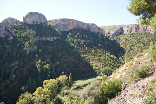 a view of a canyon with trees and mountains at El mas allà in Chulilla
