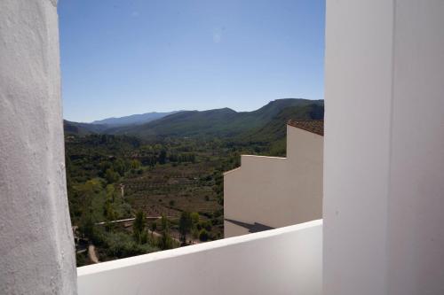 a view from the balcony of a white building with mountains at El mas allà in Chulilla