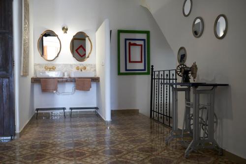 a bathroom with two sinks and mirrors and a staircase at El mas allà in Chulilla