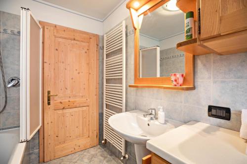 ein Badezimmer mit einem Waschbecken, einem WC und einem Spiegel in der Unterkunft Appartamento Le Coccinelle in Varena