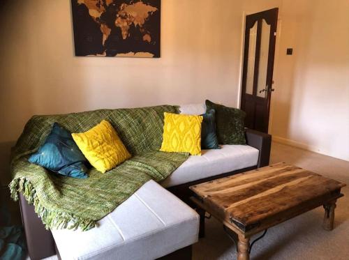 een woonkamer met een bank en een salontafel bij Lovely one-bed condo with free parking on premises in Sunderland