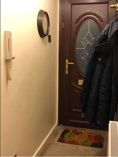 a door to a room with a clock on the wall at Lovely one-bed condo with free parking on premises in Sunderland