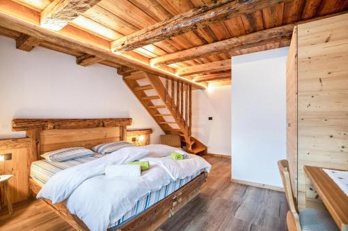 a bedroom with a large bed in a room with wooden ceilings at Chalet Osmar Appartamento 2 in Campitello di Fassa