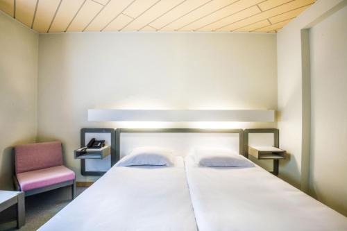 Postel nebo postele na pokoji v ubytování Hotel Le Postillon