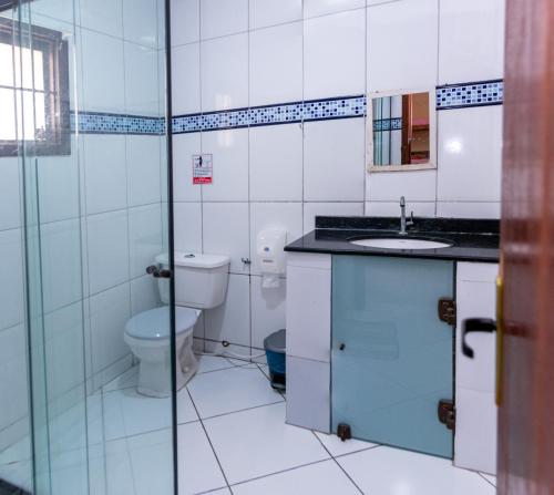 a bathroom with a toilet and a sink at Dona Rosa Suites Privativas in Arraial do Cabo