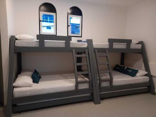 two bunk beds in a room with two mirrors at Ayenda Colombia Avenida in Medellín