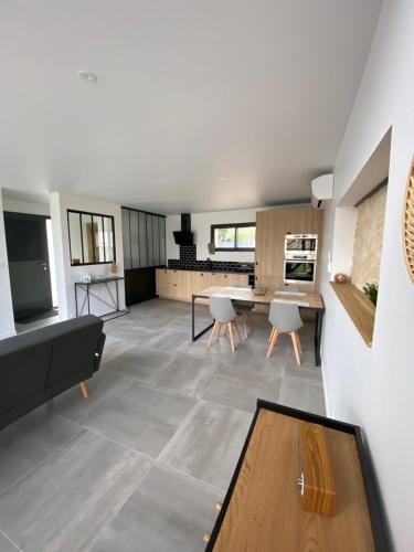 un soggiorno con un divano e un tavolo di Magnifique grange avec spa / love room a Saint-André-de-Cubzac