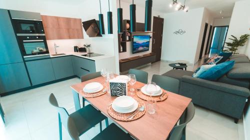 een eetkamer en een keuken met een tafel en stoelen bij Beachside Stylish & Cosy 2BR Apartment with Free Parking in Sliema