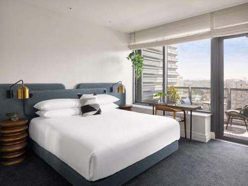 a bedroom with a large white bed and a balcony at Kimpton Alma San Diego, an IHG Hotel in San Diego