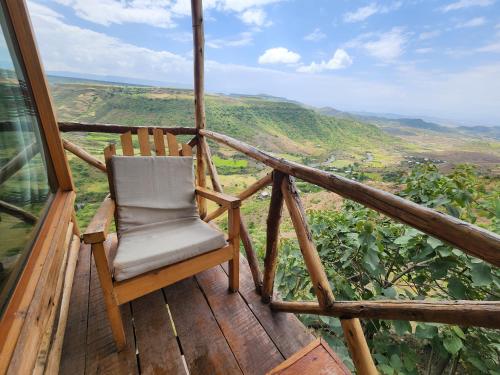 a chair sitting on top of a wooden balcony at Sora Lodge Lalibela in Lalībela