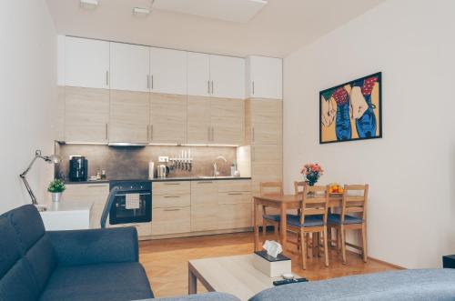a living room with a table and a kitchen at Oltec Apartment Brno in Brno