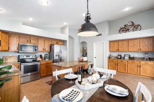 a kitchen with wooden cabinets and a table with chairs at Maricopa Home Less Than 1 Mile to The Duke Golf Course! in Maricopa