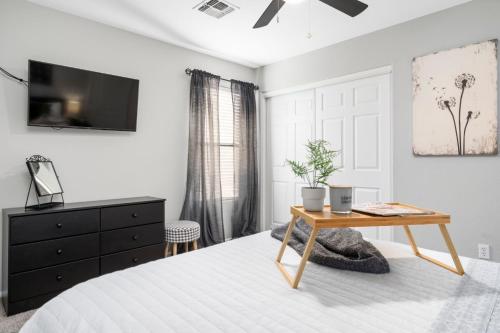 a bedroom with a bed and a table and a tv at Maricopa Home Less Than 1 Mile to The Duke Golf Course! in Maricopa