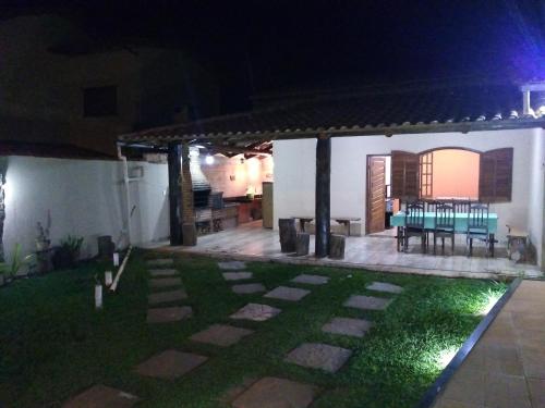 a backyard at night with a table and chairs at Casa das orquídeas in Santana do Riacho