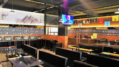 a restaurant with tables and chairs and a television at Stovehouse Inn in Ambāla