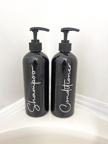 two black bottles sitting next to each other at Hamilton Chic Retreat - Comfy Beds - Garden - Pool in Hamilton