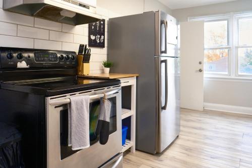 a kitchen with a stove and a refrigerator at Hamilton Chic Retreat - Comfy Beds - Garden - Pool in Hamilton