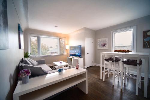 a living room with a couch and a table at Hamilton Chic Retreat - Comfy Beds - Garden - Pool in Hamilton
