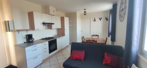 a small kitchen with a blue couch in a room at Le relais de La Poste 1 in Colombey-les-deux-Églises