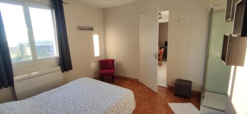 um quarto com uma cama, uma janela e uma cadeira vermelha em Le relais de La Poste 1 em Colombey-les-deux-Églises