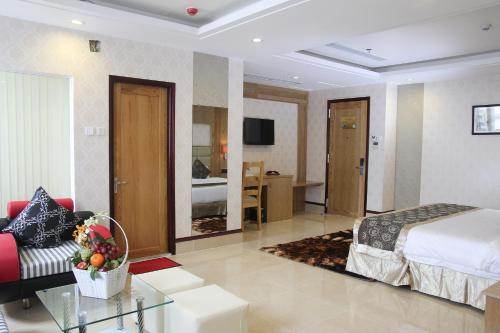 a hotel room with a bed and a living room at West Hotel in Can Tho