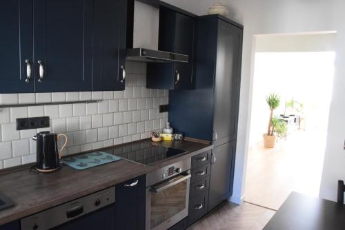 eine Küche mit schwarzen Schränken und einer Arbeitsplatte in der Unterkunft Urocze przestronne,w idealnej lokalizacji in Bielsko-Biała
