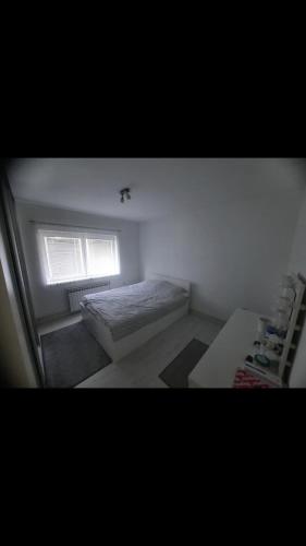 een kleine slaapkamer met een bed en een raam bij Sarajevo in Sarajevo