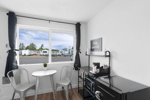 a room with a table and two chairs and a window at Silver Sands Motel in Westport