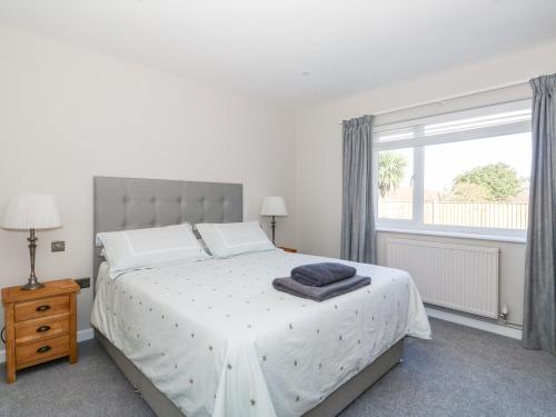 a bedroom with a large white bed with a window at Sunnyside in Wells next the Sea