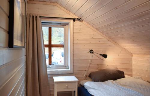 a small bedroom with a bed and a window at Nice Home In Norheimsund With Sauna, 5 Bedrooms And Wifi in Norheimsund