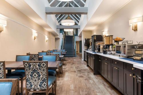 a restaurant with tables and chairs and a staircase at Independence Park Hotel, Premier Collection in Philadelphia