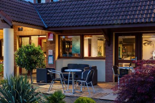 a patio with chairs and a table in front of a restaurant at Sure Hotel by Best Western Lille Tourcoing Ex Hotel Garden in Bondues