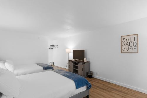 a bedroom with two beds and a tv in it at Silver Sands Motel in Westport