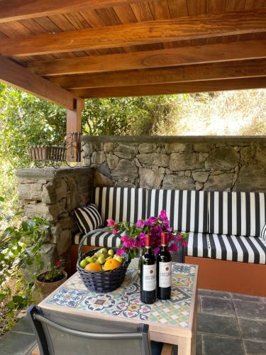 una mesa con botellas de vino y una cesta de fruta en Dúplex de invitados en medio del bosque, en Firgas