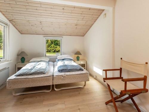 1 dormitorio con 1 cama y 1 silla en Holiday Home Nordre III en Mesinge