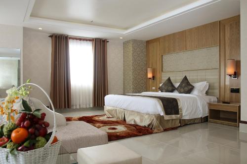 a hotel room with a large bed and a couch at West Hotel in Can Tho