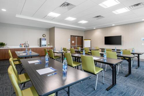 a conference room with tables and chairs and a screen at Holiday Inn Express & Suites - Ruskin by IHG in Ruskin
