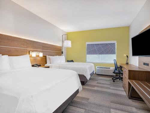 a hotel room with two beds and a flat screen tv at Holiday Inn Express & Suites - Ruskin by IHG in Ruskin