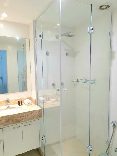 Un baño con ducha de cristal y lavabo. en APÊ DOS ANJOS - Rio de Janeiro Arraial do Cabo, en Arraial do Cabo