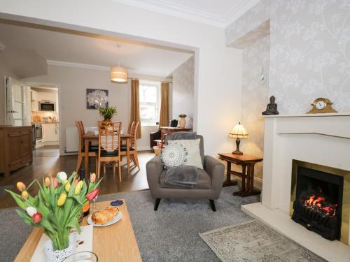 a living room with a fireplace and a chair at Bank House in Carnforth