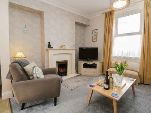 a living room with a couch and a fireplace at Bank House in Carnforth