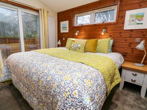 a bedroom with a bed with a wooden wall at 2 Southern Place in Liskeard