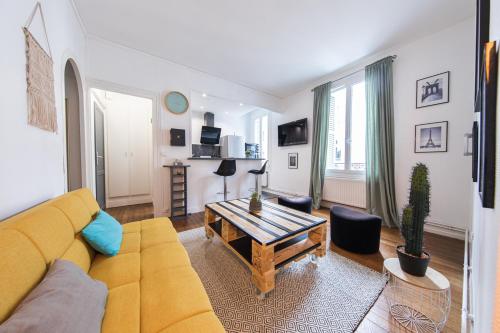 a living room with a yellow couch and a table at Appartement T2 au calme Cosy - Quartier Prébendes in Tours