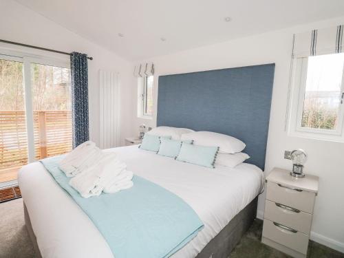 a bedroom with a large white bed with towels on it at 1 Southern Place in Liskeard